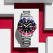 Casio watch with a silver bracelet on a red and white geometric background